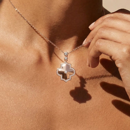 Necklace with a diamond pendant worn by a person against a neutral background