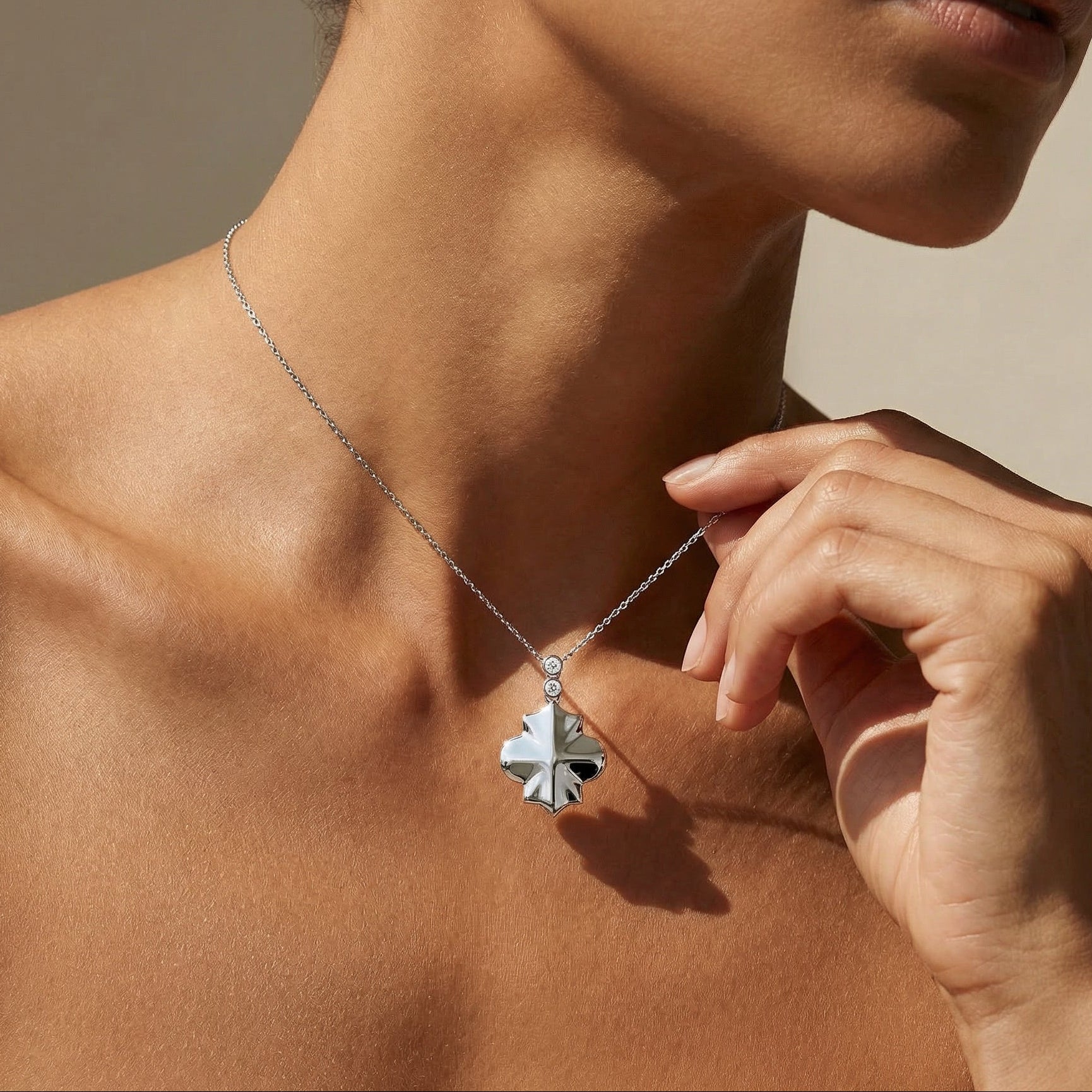White gold white diamond clover style chain necklace worn by a model 