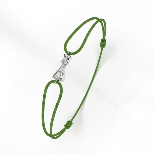A silver bracelet with a geometric patterned clasp, attached to a green cord.