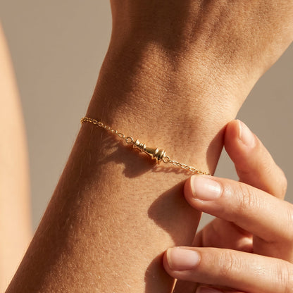 Ksenia Mirella Icon Queen Bracelet Close-up of a hand wearing a gold bracelet on a neutral background