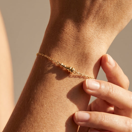Ksenia Mirella Icon Queen Bracelet Close-up of a hand wearing a gold bracelet on a neutral background
