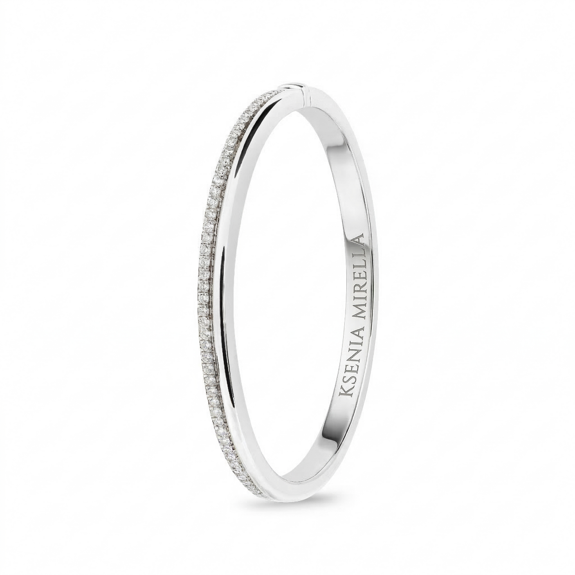 White gold bangle with 'Ksenia mirella' branding on a white background