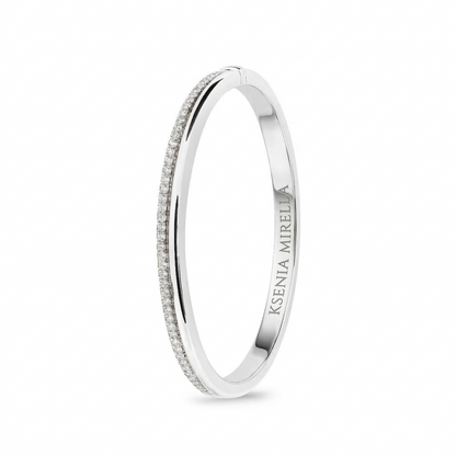 White gold bangle with 'Ksenia mirella' branding on a white background
