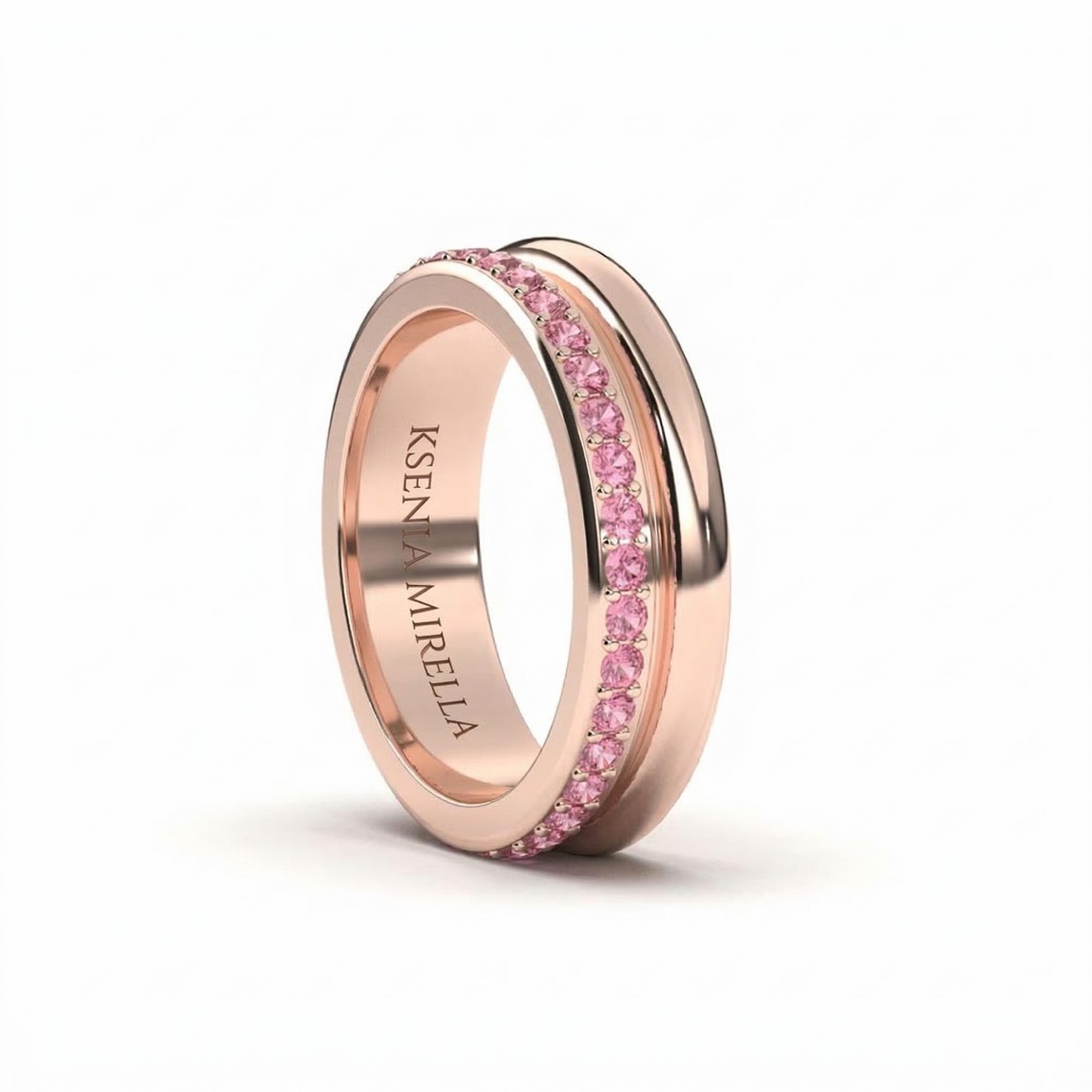 Rose gold ring with pink sapphires on a white background