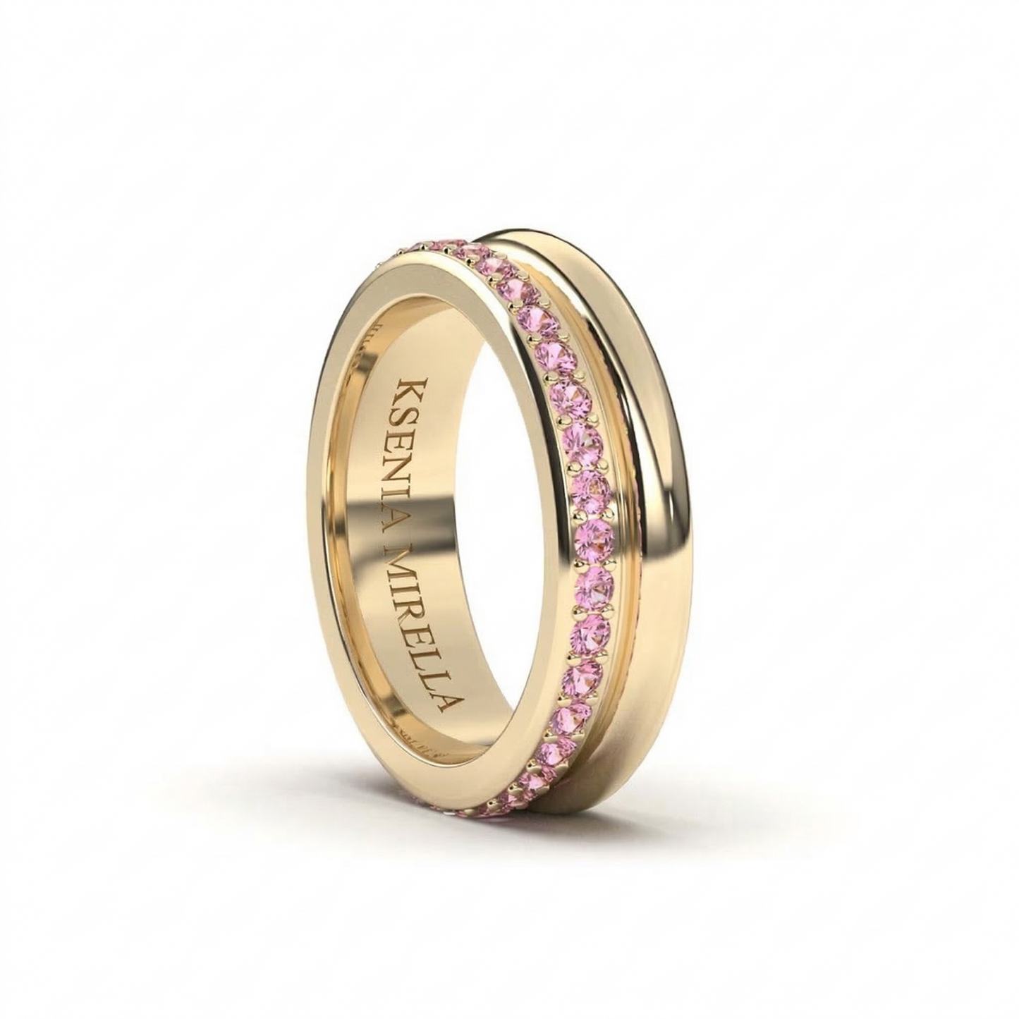 Yellow Gold ring with pink Sapphires on a white background
