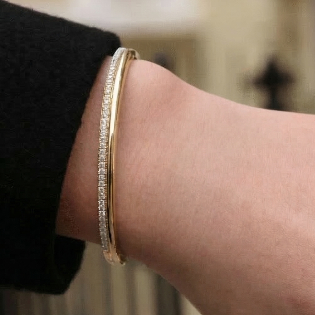 Gold bracelet on a wrist with a blurred background