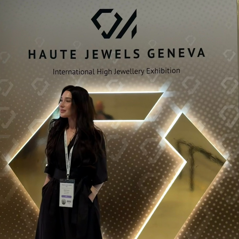 Woman standing in front of a 'Haute Jewels Geneva' exhibition sign