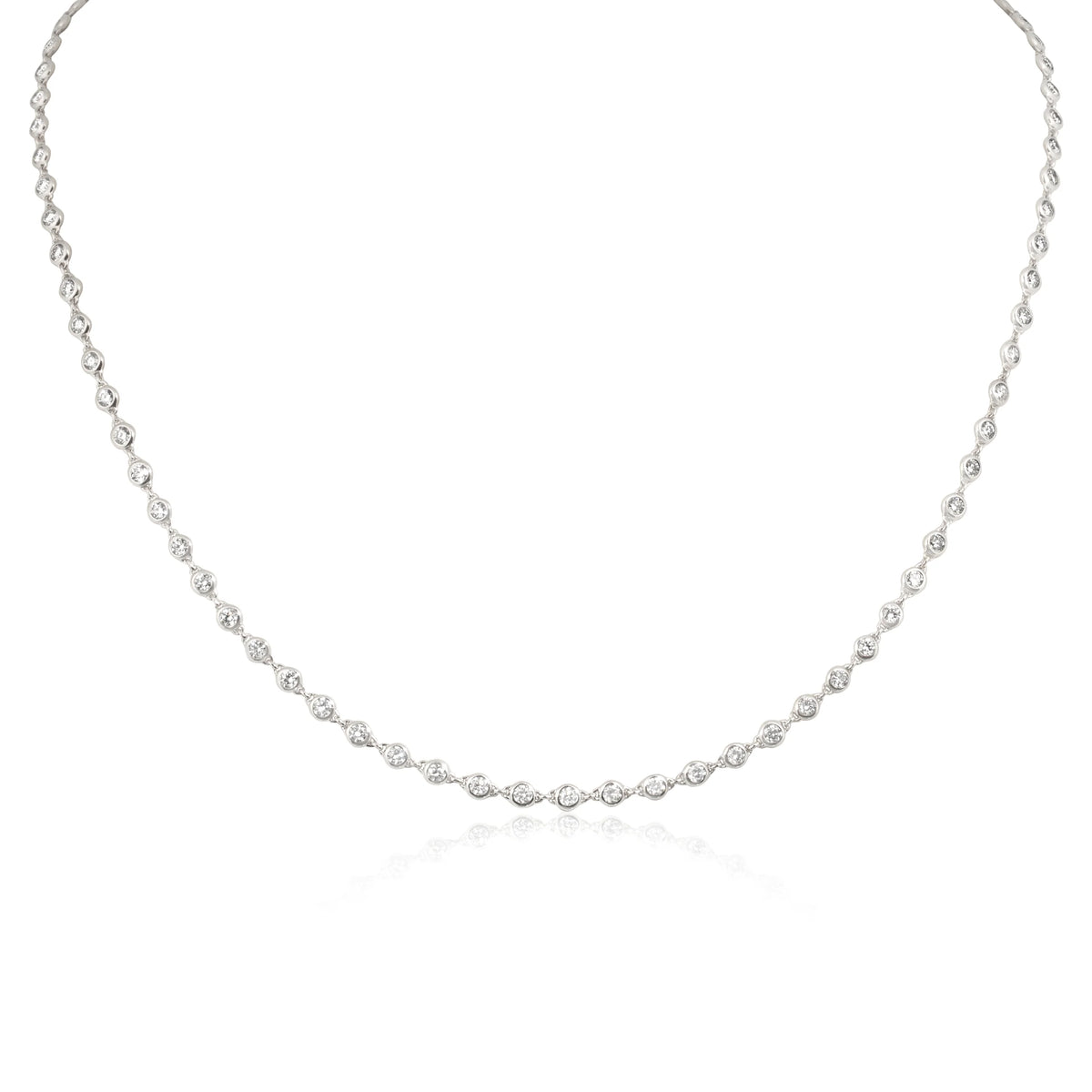 A delicate silver-toned tennis necklace featuring small marquise-cut gemstones set in a continuous line, displayed against a clean white background with a subtle reflection.