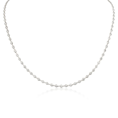 A delicate silver-toned tennis necklace featuring small marquise-cut gemstones set in a continuous line, displayed against a clean white background with a subtle reflection.