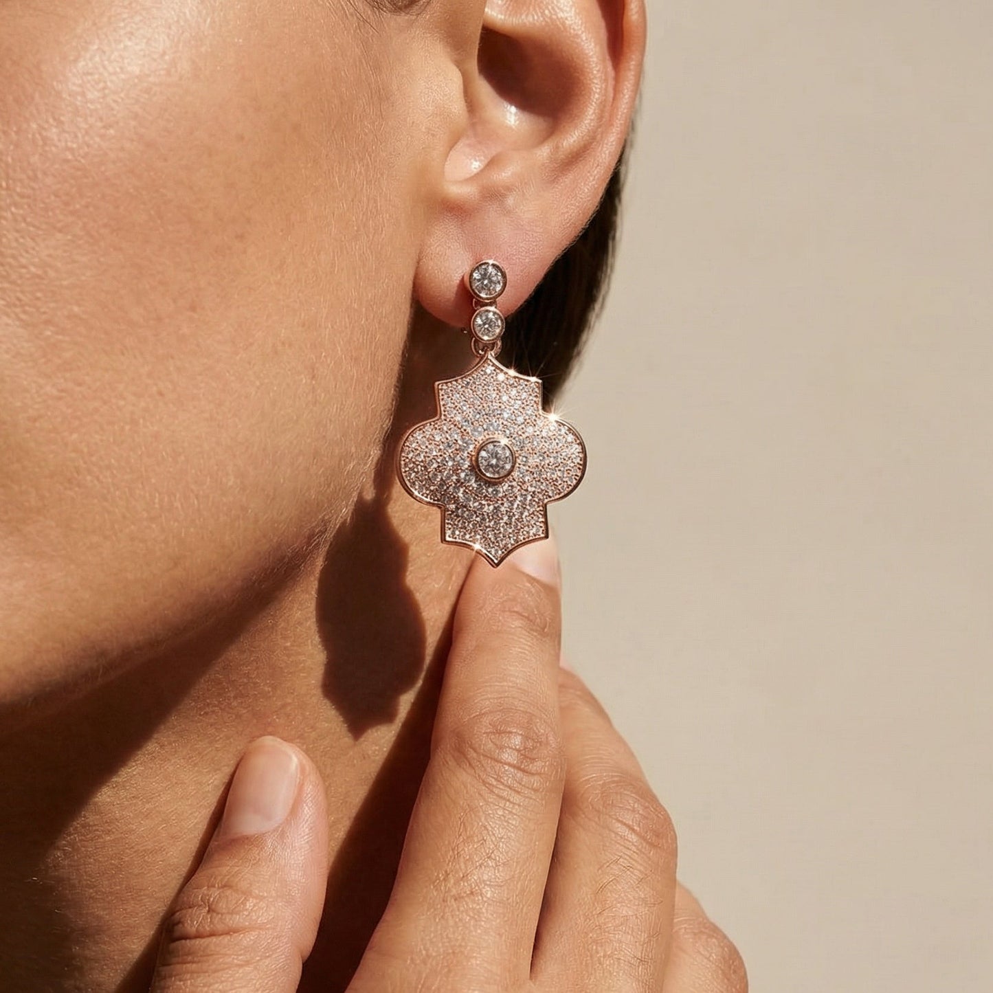 Close-up of a person wearing a sparkling earring with a neutral background