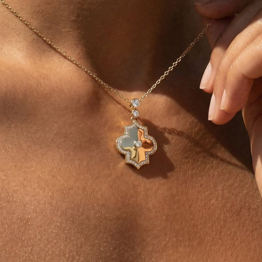 Close-up of a necklace with a pendant on a person's neck in yellow gold and white diamond 