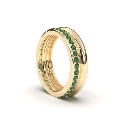 A yellow gold band ring with emerald accents.