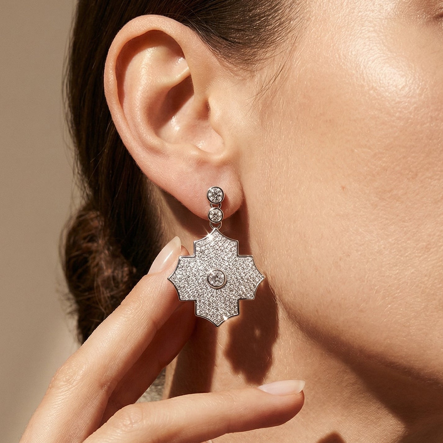 Close-up of a person wearing a star-shaped diamond earring with a neutral background